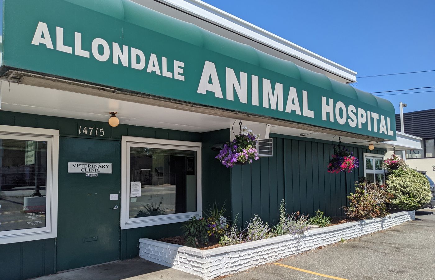 The Allondale Animal Hospital building in Surrey, with its green awning and hanging flower baskets